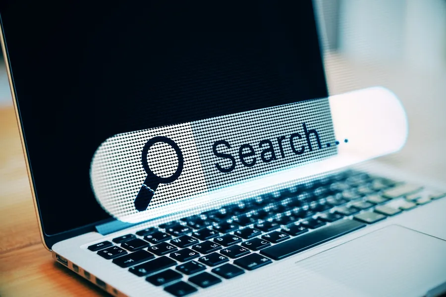 Barra de búsqueda de IA sobre un portátil, ejemplo de SEO GEO para noticias