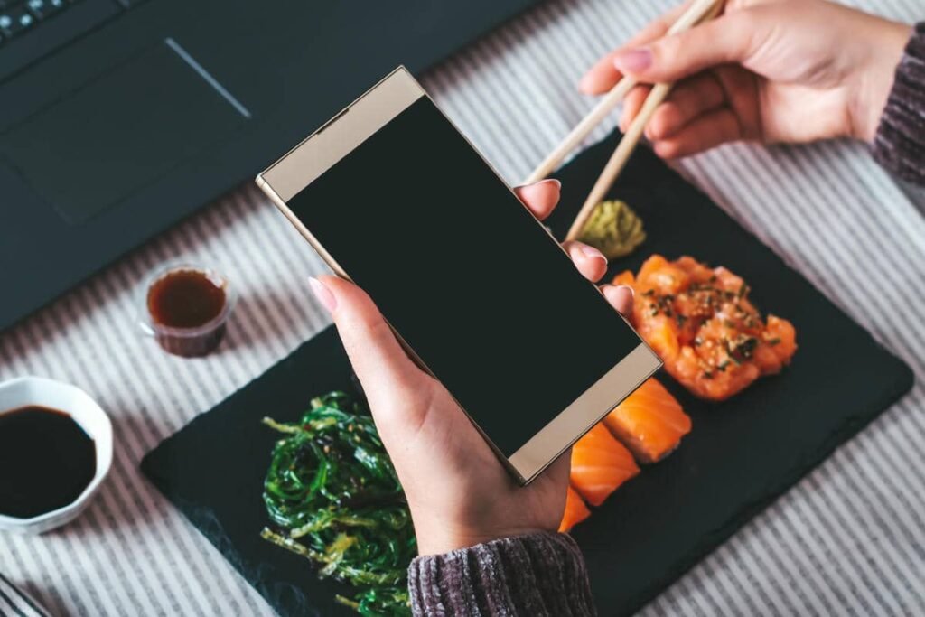 Persona con el móvil buscando un plato de sushi, afectada por una carta pdf restaurante no indexable