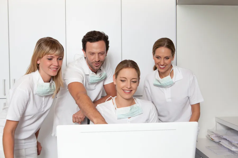 Equipo de clínica dental revisando información en pantalla, gestión de la página web para dentistas
